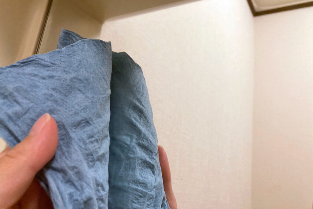 ペーパーウエスで鏡を拭く手